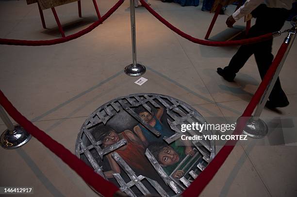 Painting named "The Forgotten" by Debora Prum is exposed during the opening ceremony of the "Hunger Free" exhibition promoted by World Vision...
