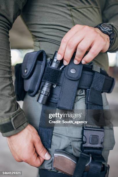 close-up of a young man standing in tactical gear - flashlight imagens e fotografias de stock