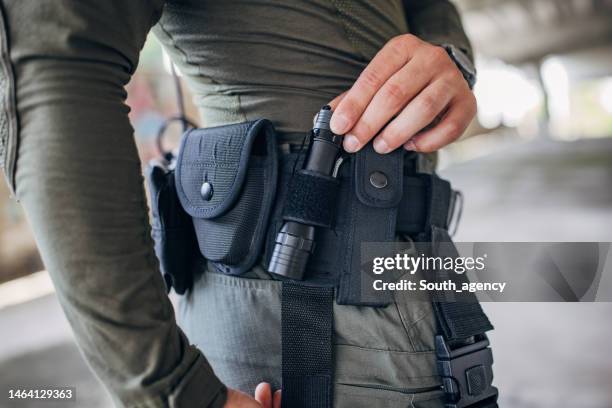 close-up of a young man standing in tactical gear - flashlight imagens e fotografias de stock