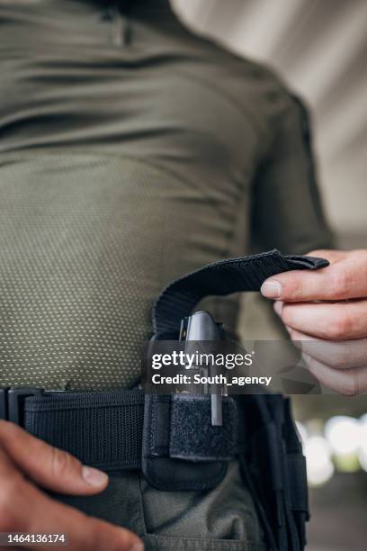 primer plano de un joven parado en equipo táctico con un soporte de spray de pimienta - pulverizador de pimienta fotografías e imágenes de stock