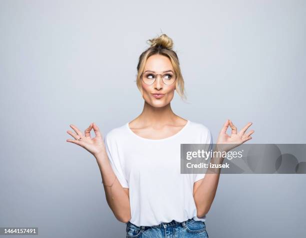 beautiful woman gesturing while looking sideways - female puckered lips stockfoto's en -beelden