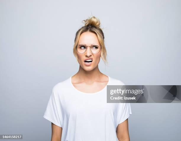 displeased woman looking away while making face - disgust face stock pictures, royalty-free photos & images