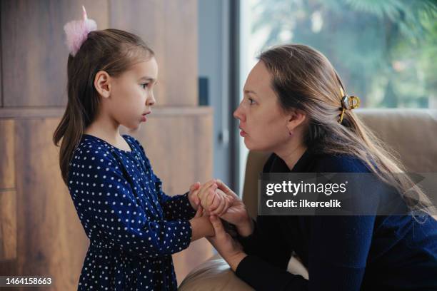 mother consoles her little sad daughter - parent and young adult stock pictures, royalty-free photos & images