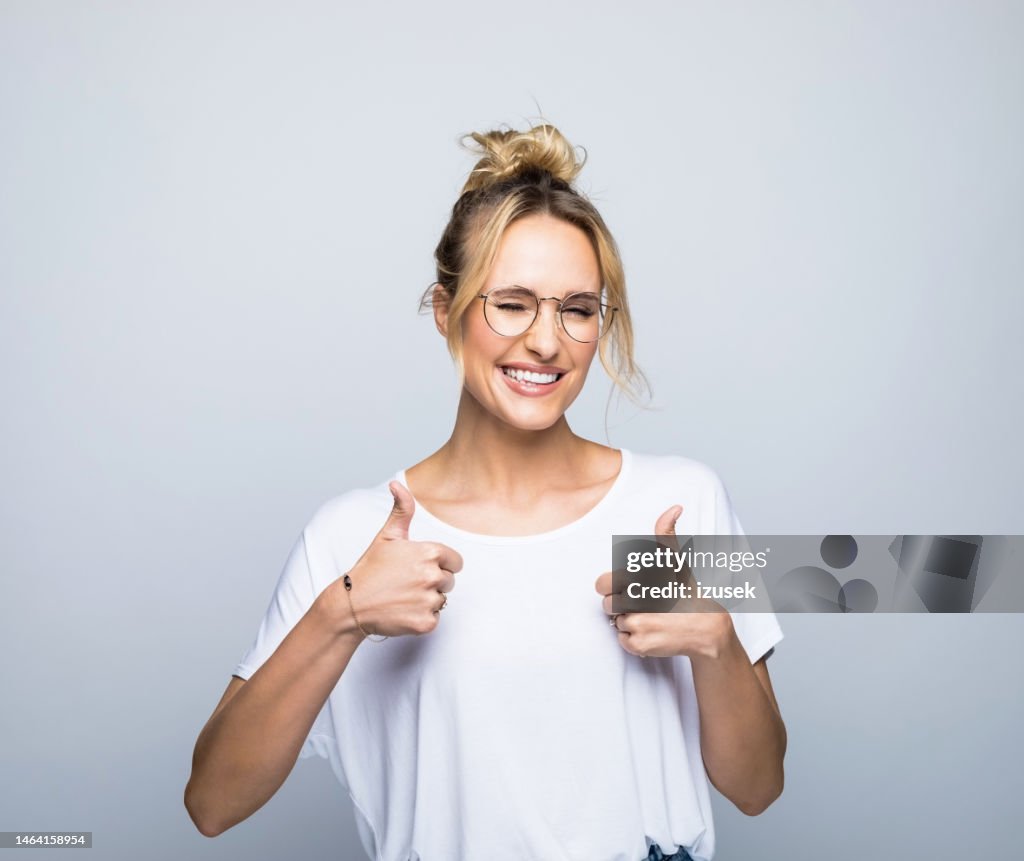 Smiling woman showing thumbs up while winking