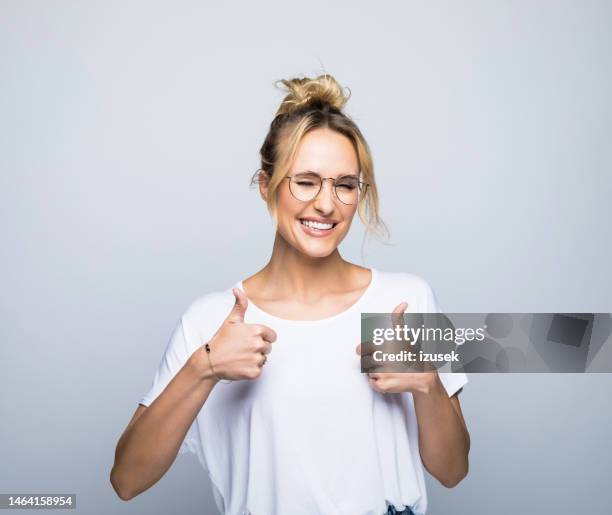 mulher sorridente mostrando polegares para cima enquanto pisca - polegar para cima - fotografias e filmes do acervo