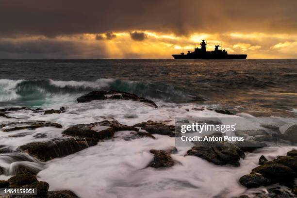 warship at sunset in the sea. fleet flagship - attack helicopter stock pictures, royalty-free photos & images