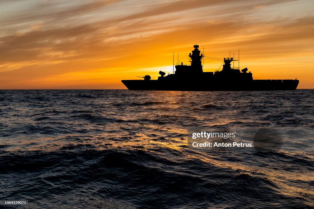 Warship at sunset in the sea. Fleet flagship