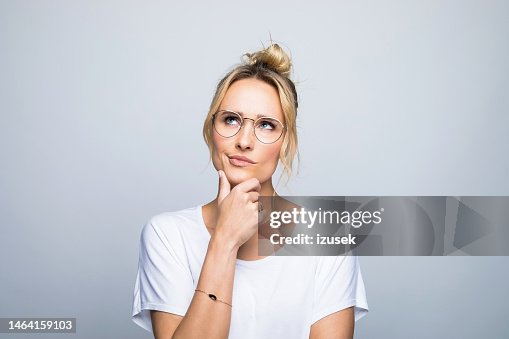 Thoughtful woman with hand on chin looking up Thoughtful woman with hand on chin looking up