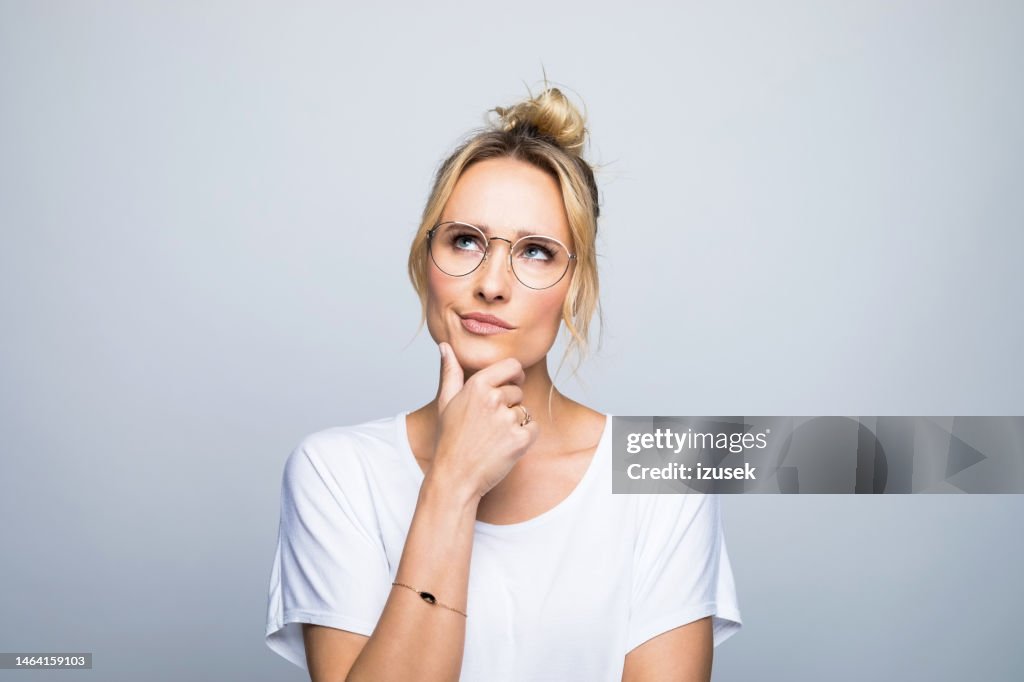 Thoughtful woman with hand on chin looking up