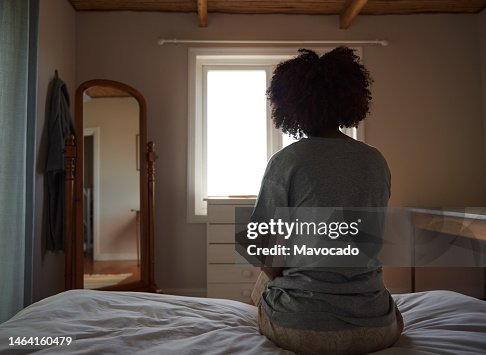 Young African woman suffering from depression sitting in her bedroom