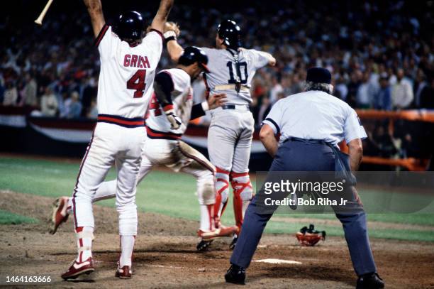 California Angels Bobby Grich raises his arms as teammate Reggie Jackson scores behind Boston Catcher Carlton Fisk during MLB playoff game, October...