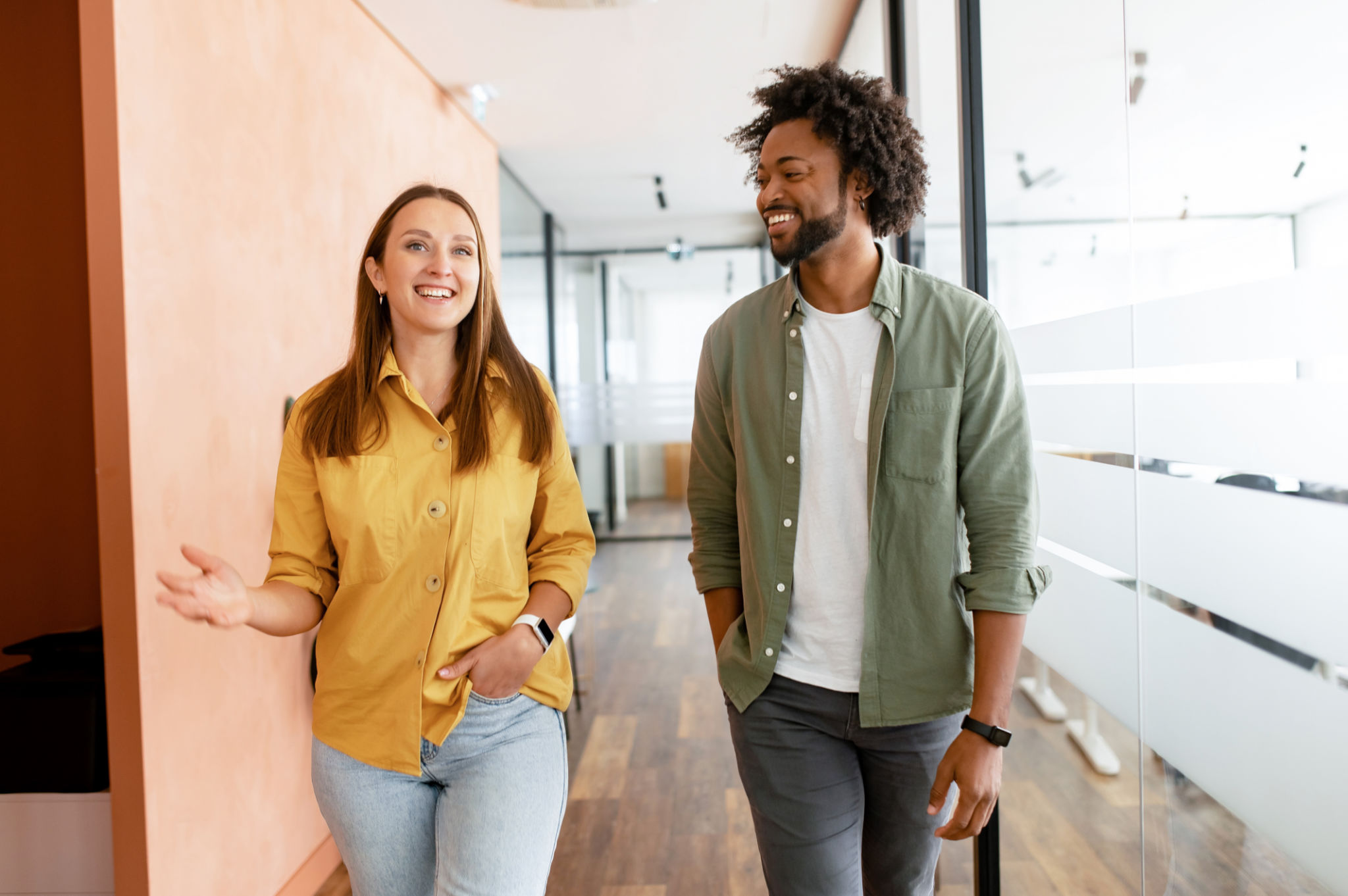 Couple of business people discussing tasks walking in the office hall Couple of business people discussing tasks walking in the office hall