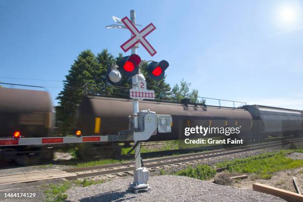 train passing car crossing. - railway crossing stock pictures, royalty-free photos & images