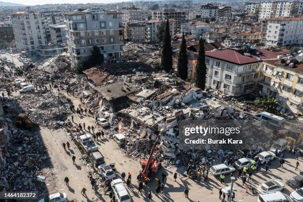 People gather around collapsed buildings on February 08, 2023 in Hatay, Turkey. A 7.8-magnitude earthquake hit near Gaziantep, Turkey, in the early...