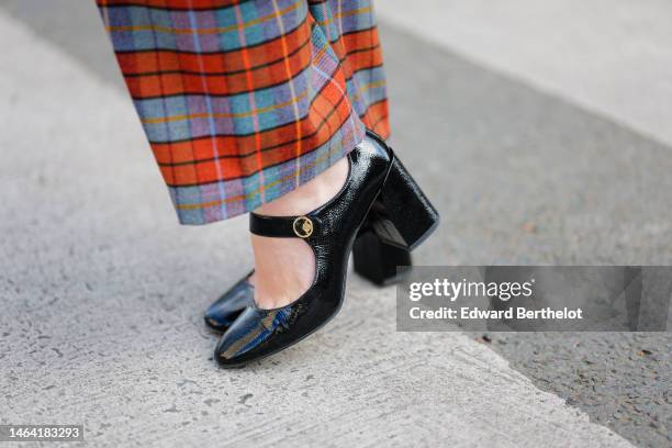 Maria Rosaria Rizzo wears red / blue / green / black checkered print pattern large wool pants, black shiny varnished leather block heels ballerinas...
