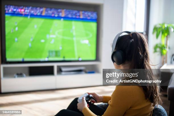 woman playing football game on gaming console. - videospel stockfoto's en -beelden
