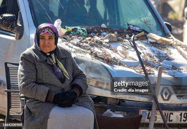 Woman sits among the debris on the street after the Maras earthquake, on February 8, 2023 in Maras, Türkiye. An earthquake with a magnitude of 7.8...