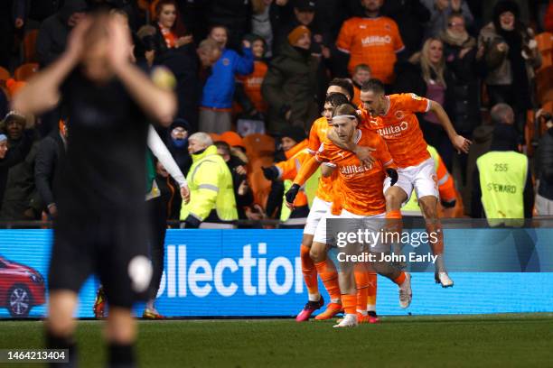 Josh Bowler of Blackpool celebrates his goal in added time with his team mates as Jordan Rhodes of Huddersfield Town holds his head in his hands...