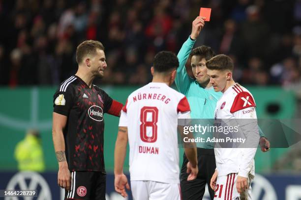 Florian Flick of 1. FC Nürnberg is shown a red card during the DFB Cup round of 16 match between 1. FC Nürnberg and Fortuna Düsseldorf at...