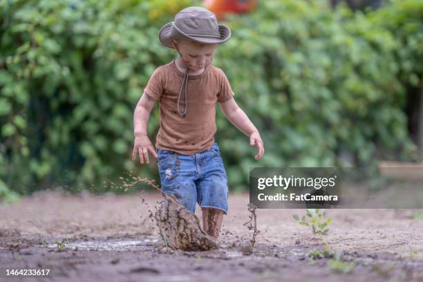 jumping in mid puddles - puddle of mud stock pictures, royalty-free photos & images