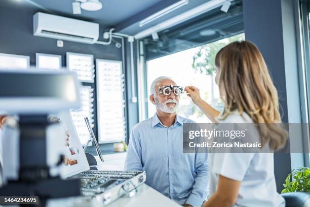 optiker wählt linse für brille passend für patienten - lens eye stock-fotos und bilder