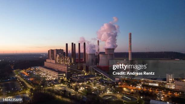 An aerial view as water vapor rises from cooling towers of the Neurath coal-fired power plant at sunset on February 08, 2023 in Neurath, Germany....