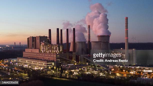An aerial view as water vapor rises from cooling towers of the Neurath coal-fired power plant at sunset on February 08, 2023 in Neurath, Germany....