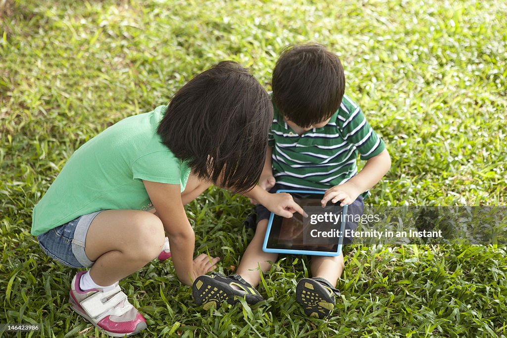 Children playing with digital tablet device