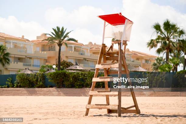 close-up photo of a single wooden baywatch box with a red roof and in the background the hotel complex - life guard stock pictures, royalty-free photos & images