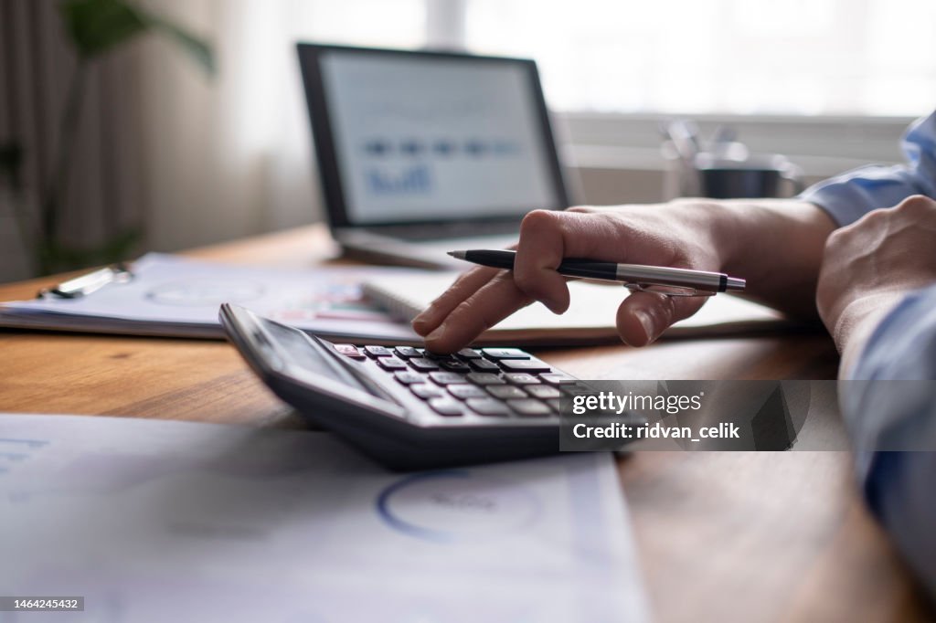 Conceito de contabilidade empresarial, Homem de negócios usando calculadora com laptop de computador, orçamento e papel de empréstimo no escritório.
