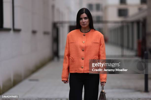 Leo Eberlin is seen wearing Zara black suit pants, Blaze Milano orange blazer with gold and pocket details and Hermes brown leather Kelly bag on...