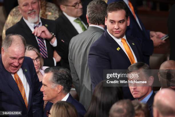 Rep. George Santos watches as Sen. Mitt Romney enters the House chamber for President Joe Biden's State of the Union address during a joint meeting...