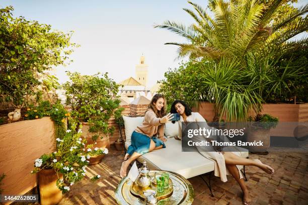 wide shot of friends taking selfie in rooftop garden of luxury hotel - memorial garden stock pictures, royalty-free photos & images