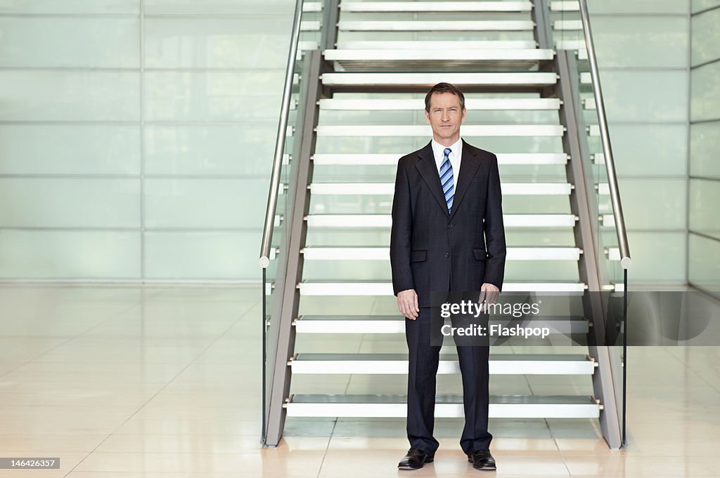 Portrait of businessman standing in modern office