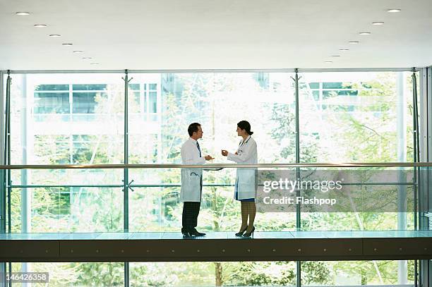 two doctors having an informal meeting - two doctors talking stockfoto's en -beelden