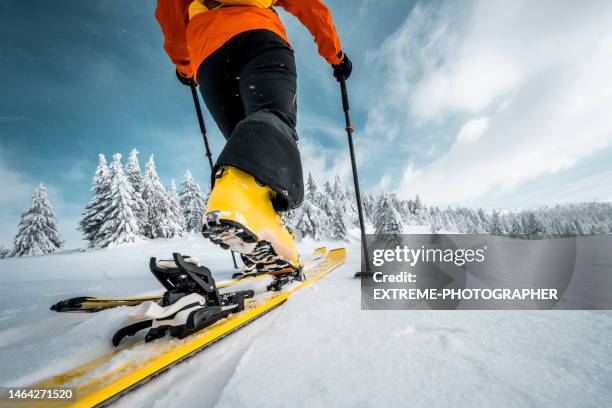 close up on a boot and a ski during ski touring adventure - skischoen stockfoto's en -beelden