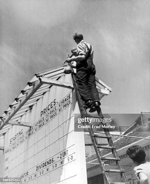 Painters smarten up the scoreboard at Ascot, in preparation for the meet, 12th June 1950.