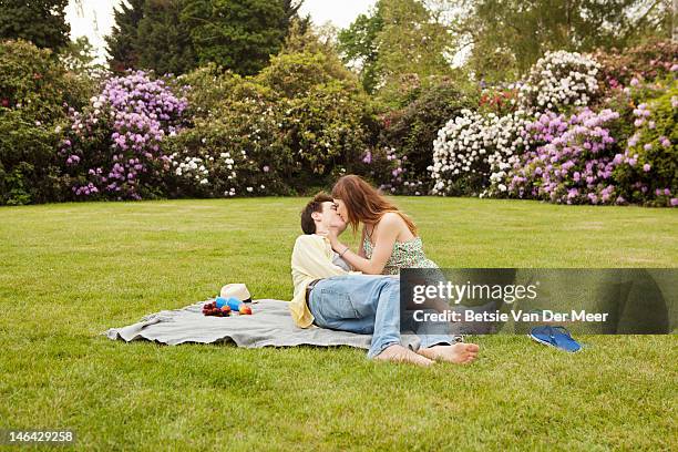 couple kissing, having picnic in park. - romantic picnic stockfoto's en -beelden