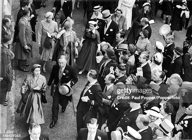 Queen Elizabeth II and Bernard Fitzalan-Howard, the 16th Duke of Norfolk stroll to the paddock at Ascot, followed by the Queen Mother, Princess...