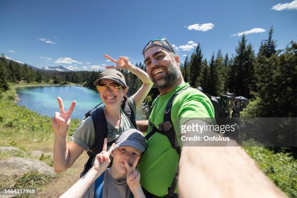 happy family taking an selfie at five lakes hiking trail, jasper, alberta, canada - summer adventure stock pictures, royalty-free photos & images