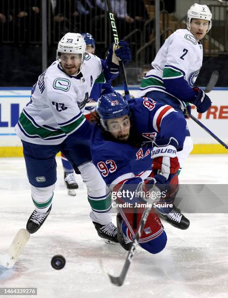 Mika Zibanejad of the New York Rangers dives for the puck as Oliver Ekman-Larsson and Luke Schenn of the Vancouver Canucks defend during the game at...