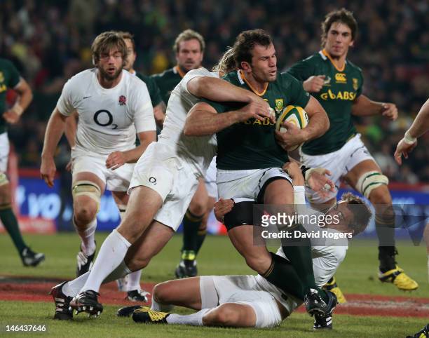 Bismarck du Plessis of South Africa is tackled by Joe Marler and Toby Flood during the second test match between South Africa and England at Ellis...