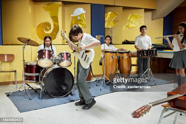 Elementary students playing instruments in music room