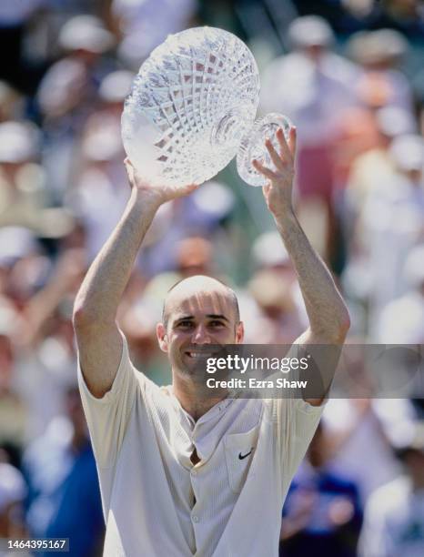 Andre Agassi from the United States holds aloft the crystal glass Men's Singles Champion Trophy after winning the Men's Singles Final match against...