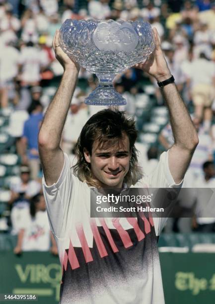 Andre Agassi from the United States holds aloft the crystal glass Men's Singles Champion Trophy after winning the ATP Lipton International Players...