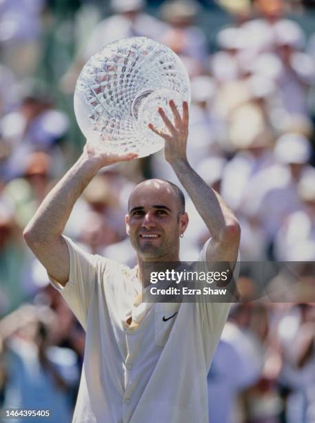 Andre Agassi from the United States holds aloft the crystal glass Men's Singles Champion Trophy after winning the Men's Singles Final match against...