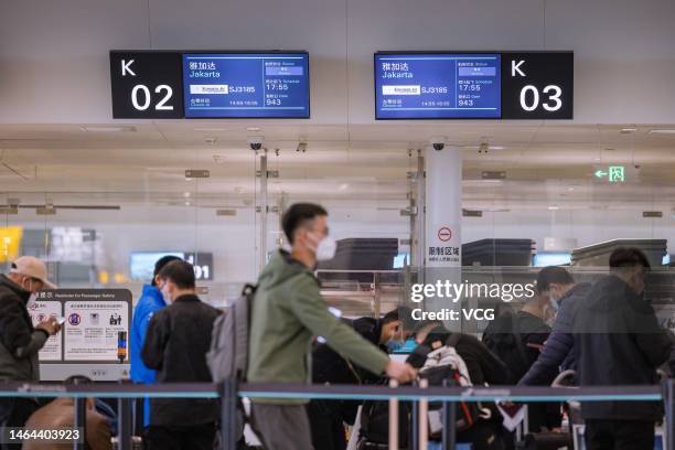 Travelers of an outbound tour group to Bali in Indonesia check in at Hangzhou Xiaoshan International airport on February 8, 2023 in Hangzhou,...