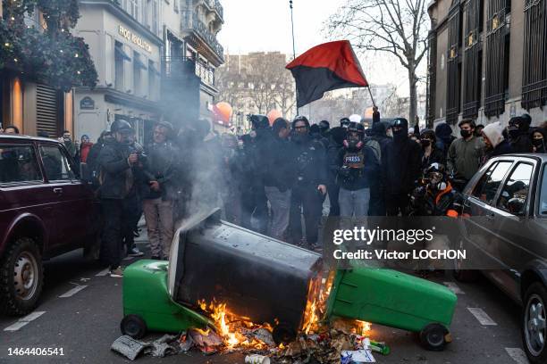 Manifestants avec un drapeau noir et rouge symbole de rébellion et feu de poubelle lors de la manifestation contre la réforme allongeant la retraite...