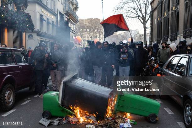 Manifestants avec un drapeau noir et rouge symbole de rébellion et feu de poubelle lors de la manifestation contre la réforme allongeant la retraite...