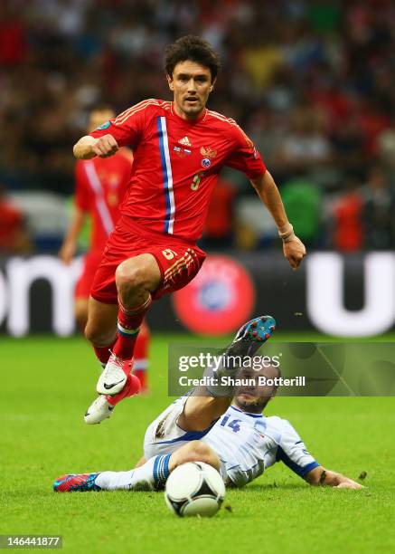 Yuriy Zhirkov of Russia jumps over the challenge by Dimitris Salpigidis of Greece during the UEFA EURO 2012 group A match between Greece and Russia...